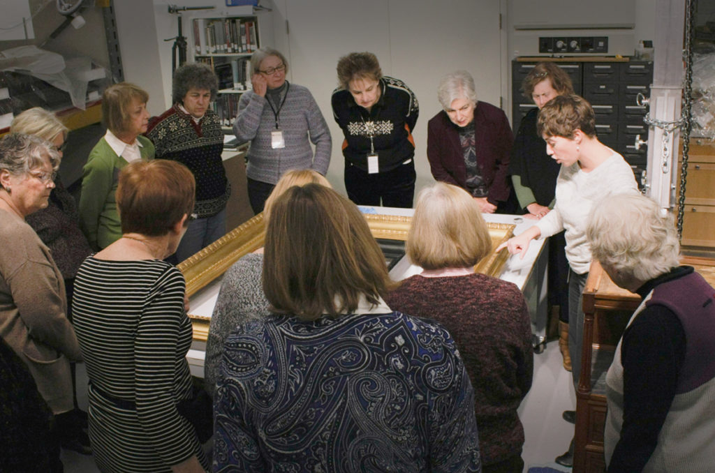 Chief Conservator, Megan Emery, detailing the damage on a frame to MACC visitors from a museum patrons group.