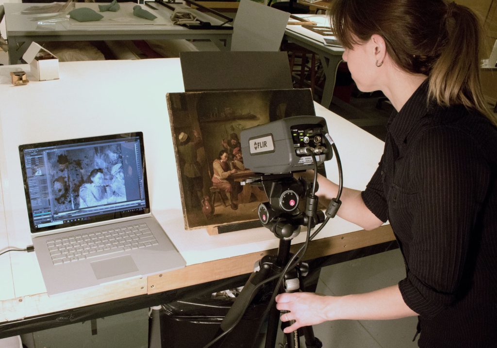 A practitioner using a FLIR device to analyze a work