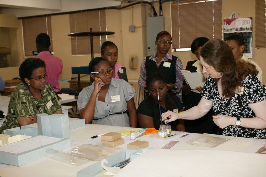 A MACC employee demonstrating mixing of materials to students at a workshop
